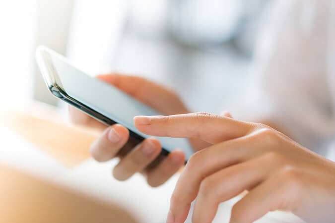 Mãos femininas enviando SMS